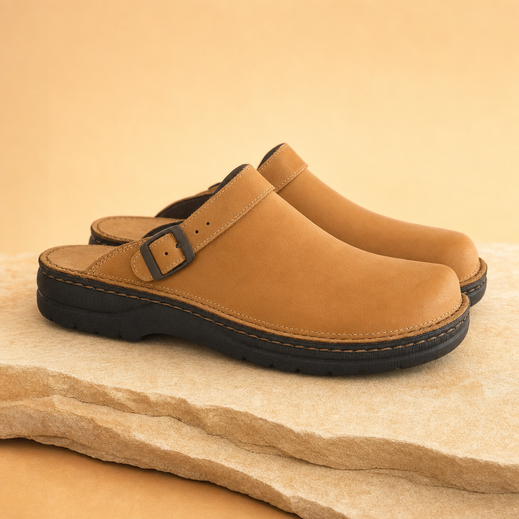 Comfora men's brown leather slippers on a warm beige studio backdrop